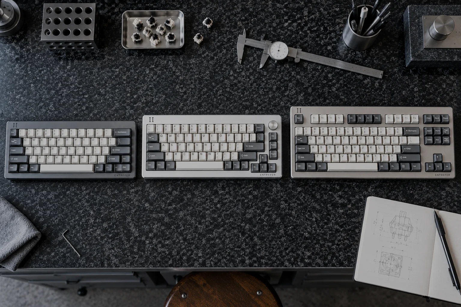 The three ENTREFER boards side by side on a granite surface plate, seen from above: VERNIER 61 in Ardoise, CADRAN 68 in Neige with its encoder, ÉTALON 87 in Grès.